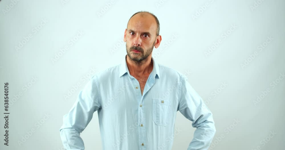 A middle-aged man making facial expressions that show he doesn't believe the situation in front of him in a studio environment A middle-aged man making facial expressions that show he doesn't believe the situation in front of him in a studio environment