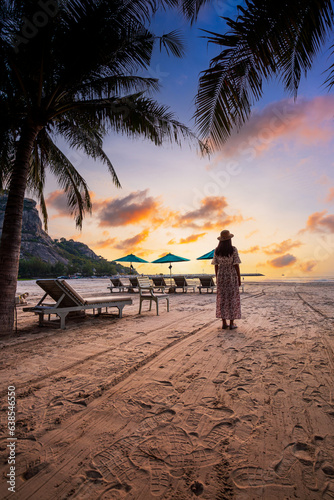 Woman and beach in the morning Summer travel vacation concept  Traveler asian woman with hat relax and sightseeing on Kata beach at sunset in Phuket  Thailand