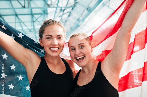 Athlete women, usa flag and celebration for win, fitness and excited in portrait at sports contest. Girl team, winner and together by swimming pool with success, exercise and goals at competition