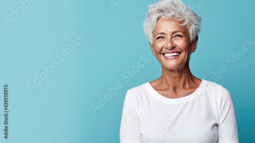 Senior female standing in front of camera in white T-shirt , isolated on blue background