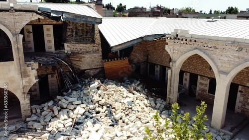 Historic Inn in Adiyaman, Turkey damaged by earthquake, with collapsed roof and debris.