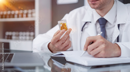 doctor holding pills and making notes in a notebook