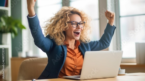 Successful entrepreneur celebrating with fist pump in front of laptop.  photo