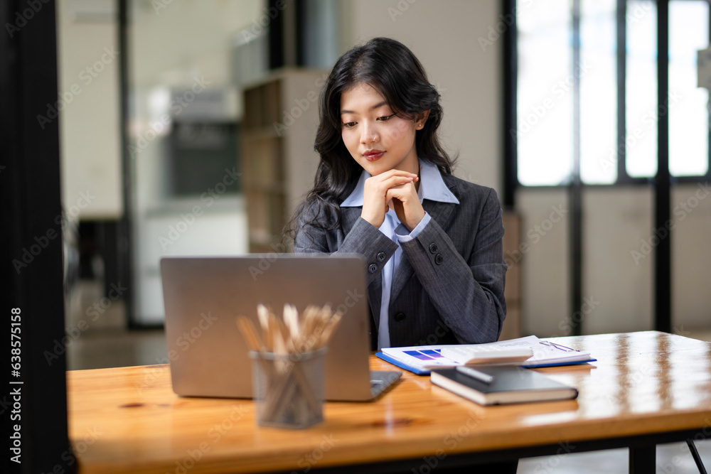 business woman looking at laptop and contemplating plans business woman looking at laptop and contemplating plans