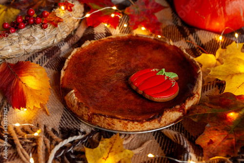 Traditional American Homemade pumpkin pie on a rustic table with cosy autumn decorations and maple leaves photo