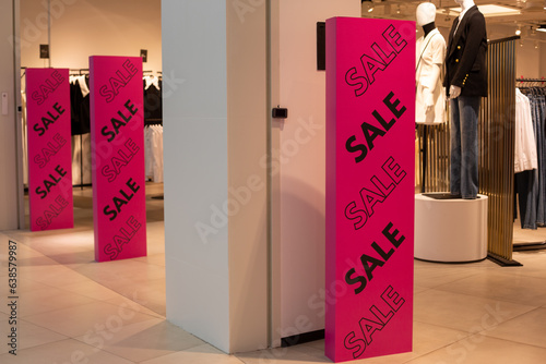 Bright purple anti-theft gate at the entrance to a clothing store with a black sale inscription. Discounts and promotions at the entrance to a modern clothing store on a metal detector