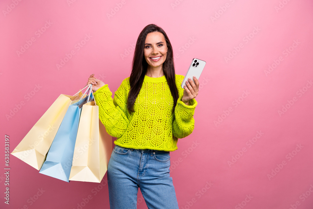 Portrait of positive woman with straight hair wear yellow pullover order new closes hold smartphone isolated on pink color background Portrait of positive woman with straight hair wear yellow pullover order new closes hold smartphone isolated on pink color background
