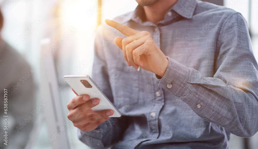 businessman using mobile phone to send message in office