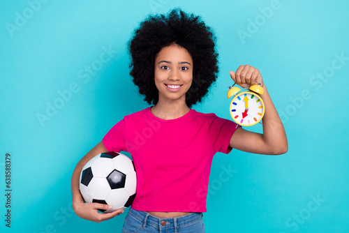Photo of cute cheerful schoolgirl arms hold football bell ring clock wear crop top isolated on teal color background © deagreez