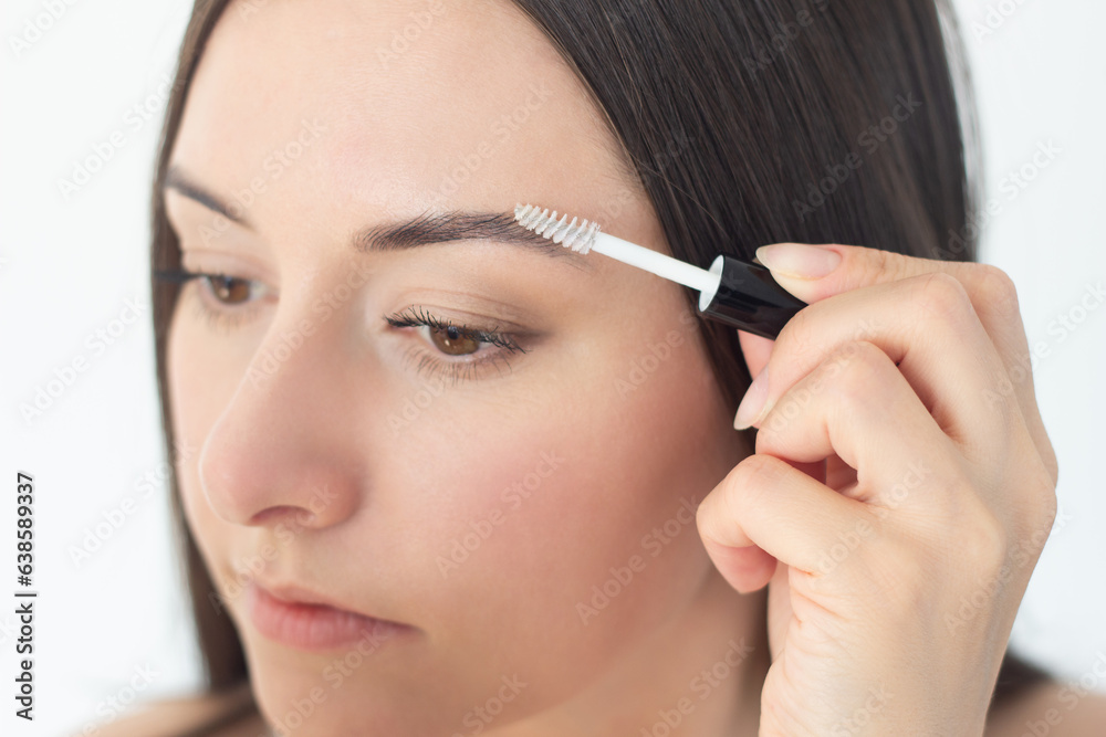 close-up of the face of a young pretty woman who takes care of her eyebrows, doing styling with an eyebrow fixator. close-up of the face of a young pretty woman who takes care of her eyebrows, doing styling with an eyebrow fixator.