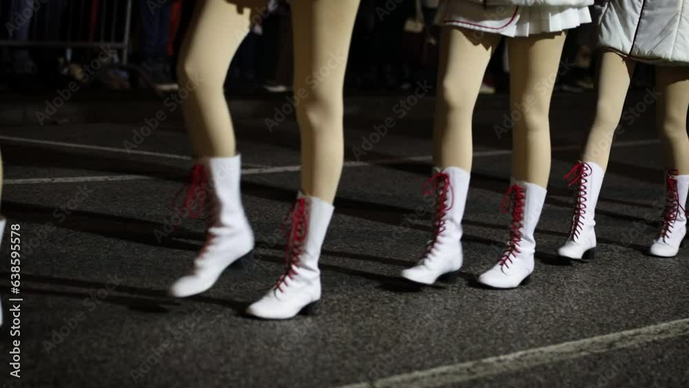 Majorettes March in a Row on the street in the evening - Close up in the legs and Ground Majorettes March in a Row on the street in the evening - Close up in the legs and Ground
