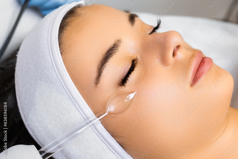 Hardware vacuum facial massage for skin smoothness. Woman enjoys