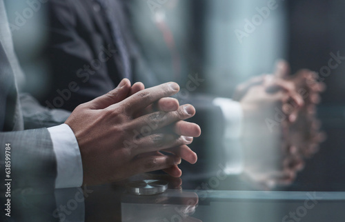 Manager listening to the report of colleagues sitting at the table in a dark office