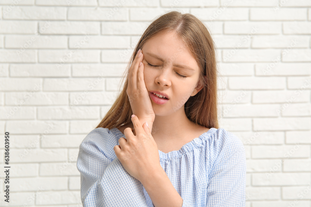 Young woman suffering from toothache on white brick background Young woman suffering from toothache on white brick background