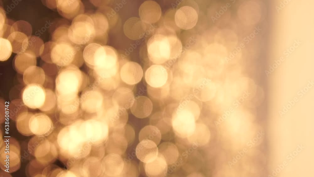 Abstract sea summer ocean sunset nature background. Small waves on golden water surface in motion blur with golden bokeh lights from sun. Holiday, vacation and recreational concept. Vertical video.