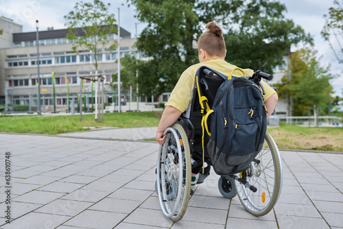 Fototapeta Naklejka Na Ścianę i Meble -  Back view, child preteen boy on wheelchair going to school building