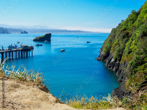 Calm bay with cliff, pier, rocks and boats, Eureka California