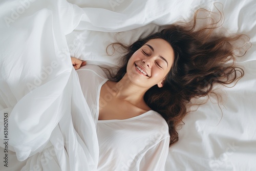 Woman happily sleeping on bed with white blanket.