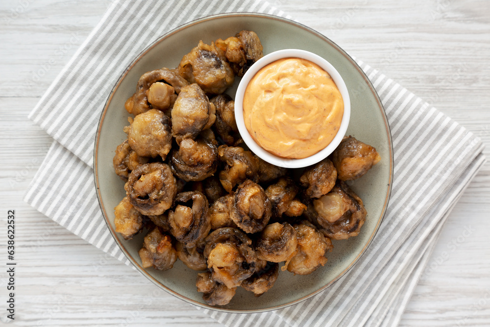Homemade Crispy Deep Fried Mushrooms with Spicy Mayo on a Plate on a white wooden background, top view. Homemade Crispy Deep Fried Mushrooms with Spicy Mayo on a Plate on a white wooden background, top view.