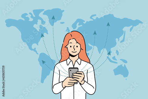 Woman with phone uses 5G technology standing near world map and exchanging information with international servers. Girl with smartphone is addicted to surfing net thanks to fast 5G connection