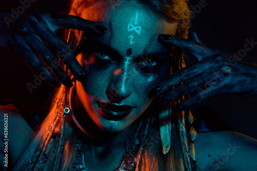 Photo of sexy attractive mysterious lady wear viking clothes applying ritual make up isolated dark blue color background