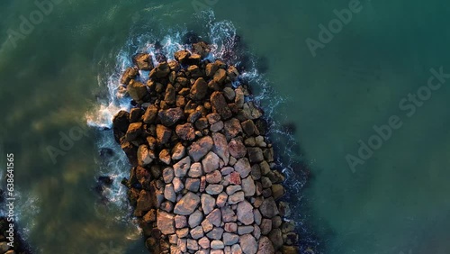 Rotating top view of a rocks groyne with splash water