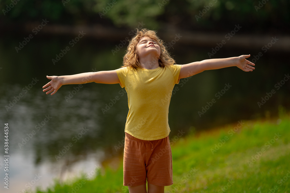 Happy child with arms up enjoying freedom in nature. Child with open arms meditates. Child enjoying freedom raising arms up. Child feelings of freedom in nature. Kid in summer nature. Calmness relax. Happy child with arms up enjoying freedom in nature. Child with open arms meditates. Child enjoying freedom raising arms up. Child feelings of freedom in nature. Kid in summer nature. Calmness relax.