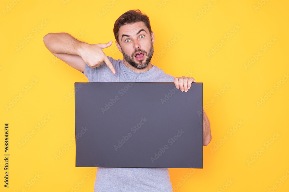 Man showing promo holding pointing finger on blank board on studio background. Blank signboard with copyspace. Advertisement concept. Ad board with copy space, blank mockup. Blank signboard, placard. Man showing promo holding pointing finger on blank board on studio background. Blank signboard with copyspace. Advertisement concept. Ad board with copy space, blank mockup. Blank signboard, placard.