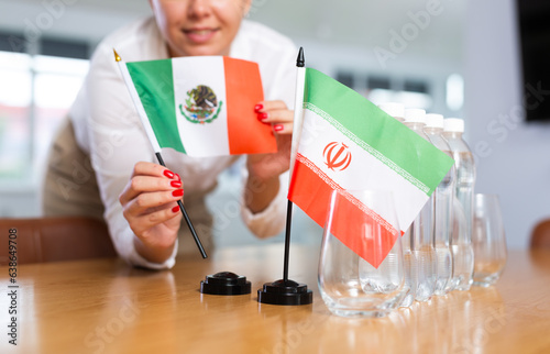 Secretary shows the flags of Mexico and Iran on the table. Preparing for a meeting, negotiations. photo