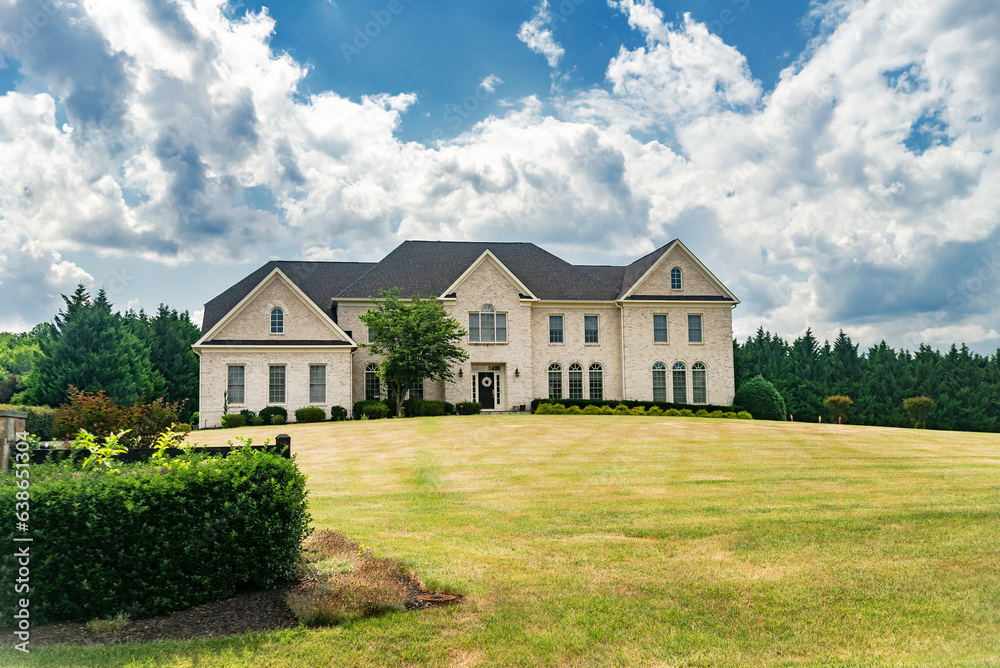 Obraz premium Country luxury house on hill under blue clouds.