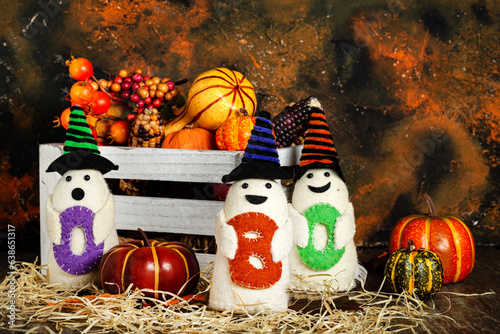 BOO ghost toys with pumpkins and autumn leaves. Halloween holiday concept.