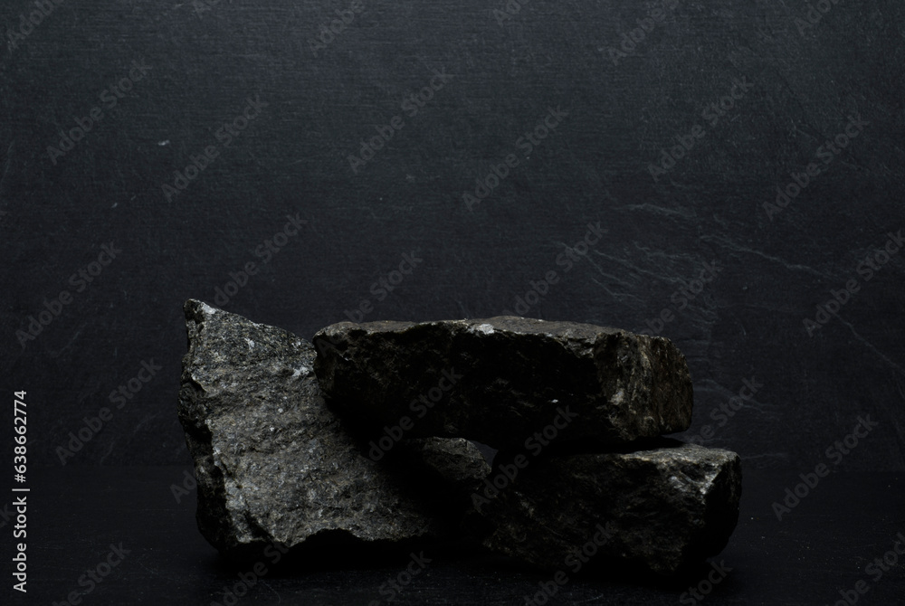 Naklejka premium podium stones.black stones on dark gray background for podium product presentation