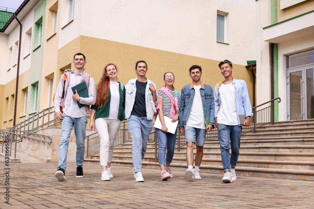 Obraz premium Group of happy young students walking together outdoors