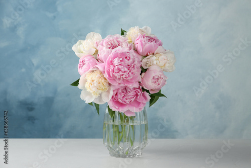 Fototapeta Naklejka Na Ścianę i Meble -  Bouquet of beautiful peonies in glass vase on white table