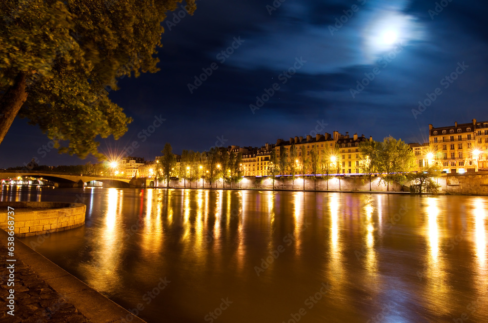 River Seine and Pont du Carrousel bridge at night in Paris France.