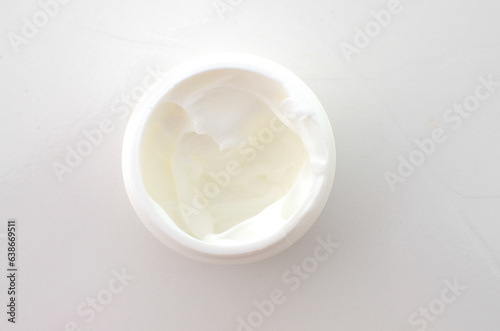 Close-up of a small jar of white cream, a symbol of beauty care and skin health.