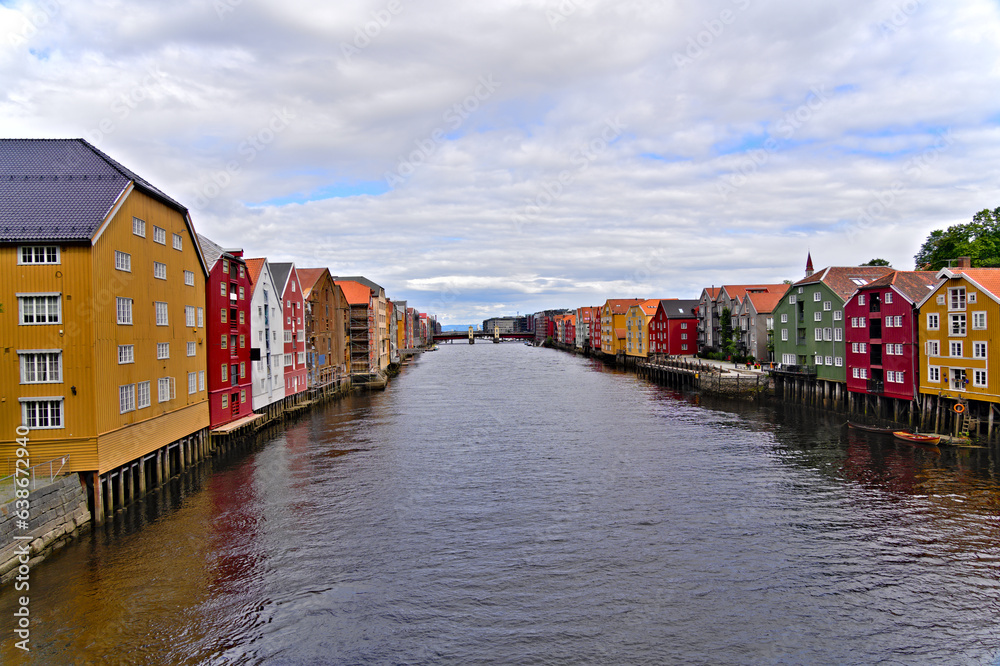 Historic old wooden buildings and houses with colorful facades over the river Nidelva in the Brygge district, in the scenic Scandinavian harbor city of Trondheim, Norway travel destination