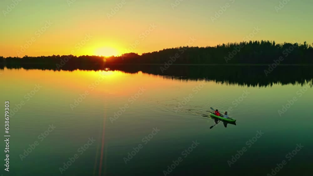 Epic golden hour sunset spreads light across calm lake, loving couples enjoys date night on water Epic golden hour sunset spreads light across calm lake, loving couples enjoys date night on water