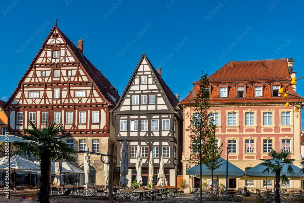 Häuserensemble von drei alten Patrizierhäusern am Marktplatz in der historischen Altstadt von Schwäbisch Gmünd mit Straßencafe im Vordergrund