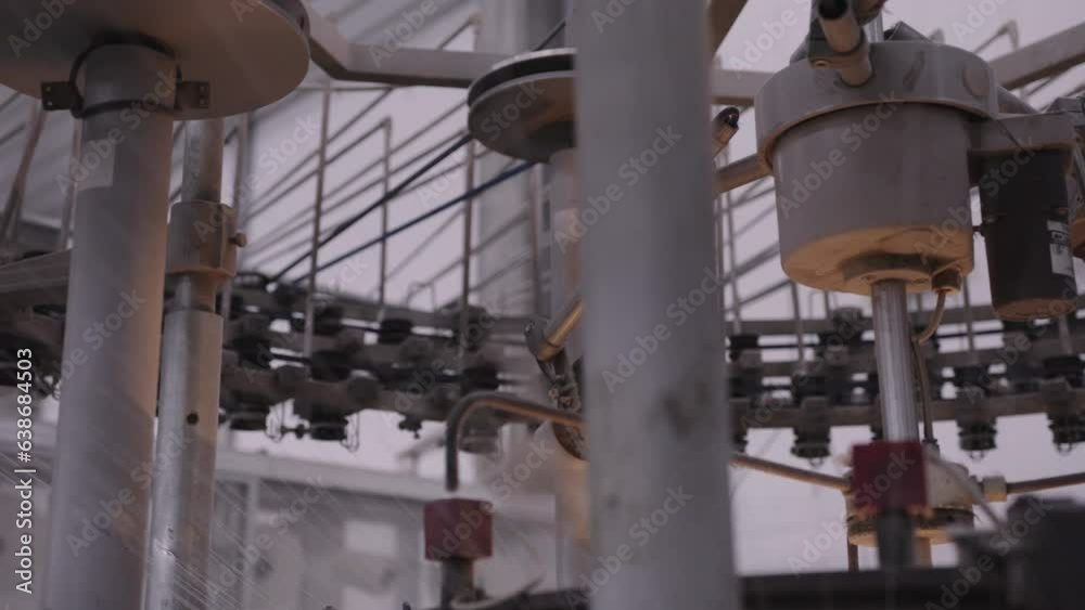 Mid shot of high tech machinery in factory weaving material Mid shot of high tech machinery in factory weaving material