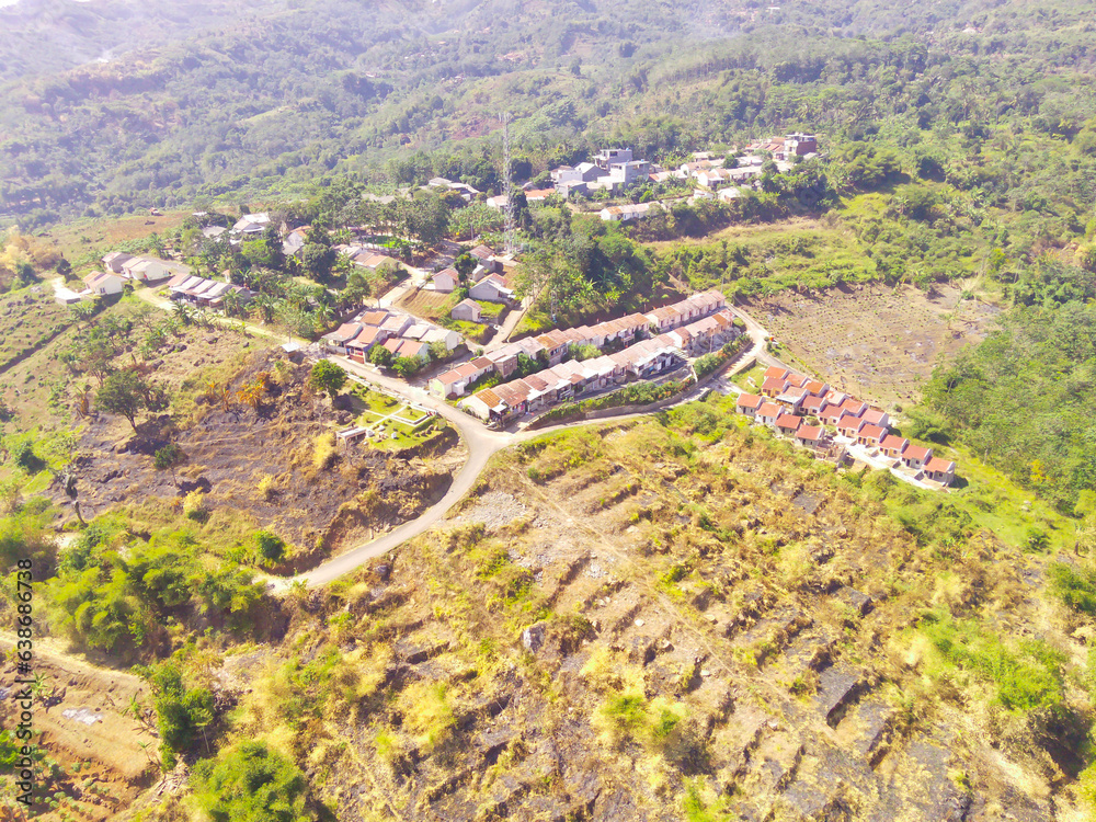 Aerial View of the beautiful Village on top of the mountain. Aerial Drone Shot. Vibrant village in serene countryside with charming architecture and lush greenery.. Bandung - Indonesia