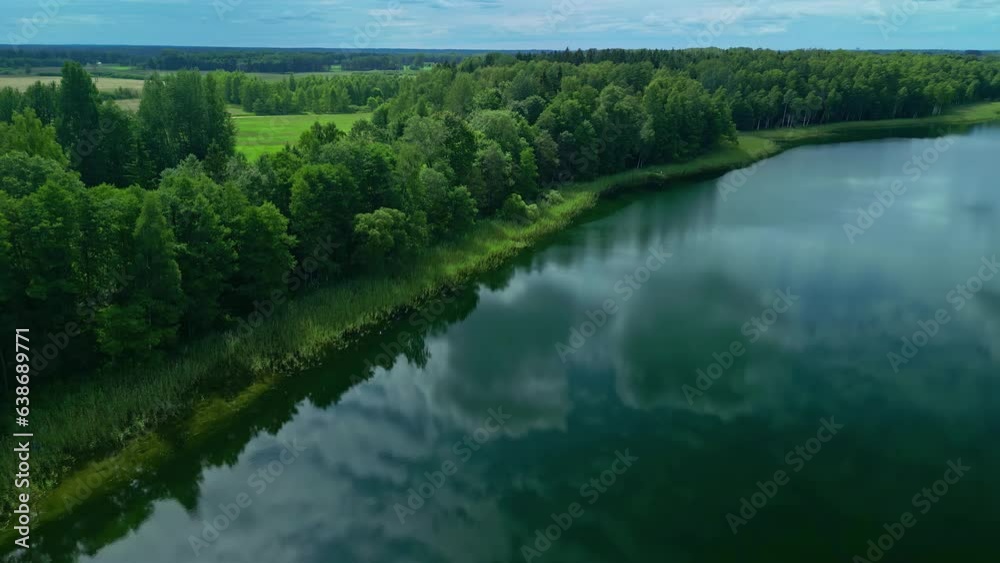 Stormy clouds reflecting on calm lake water, aerial drone view