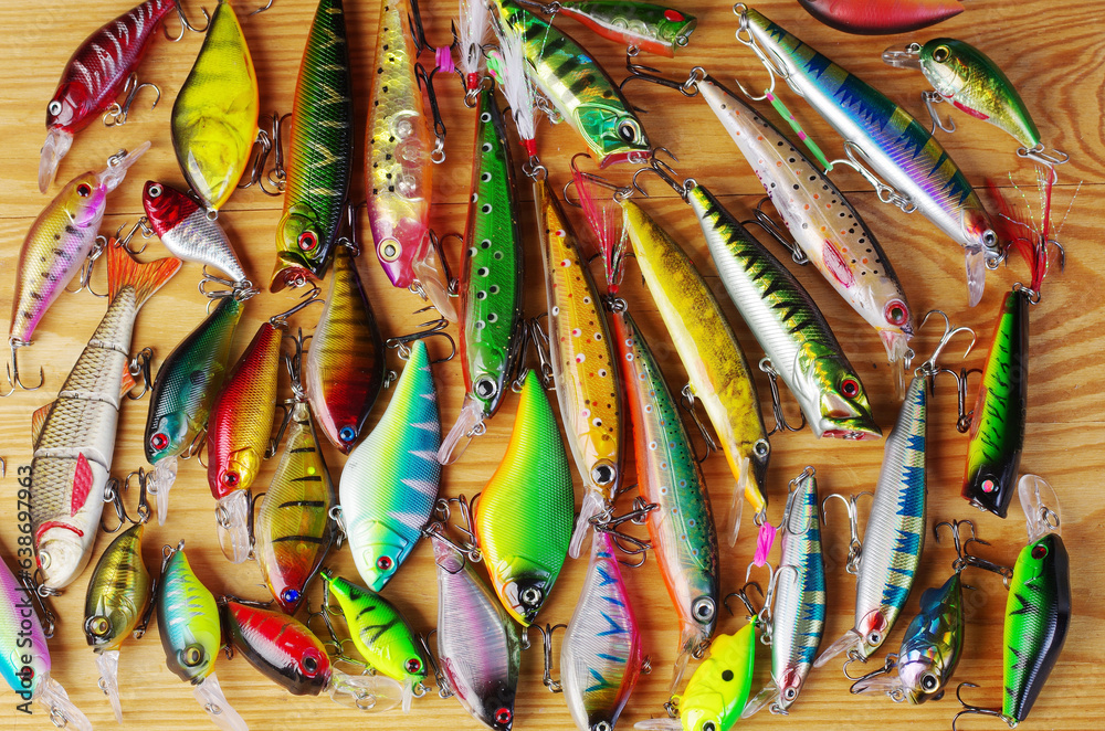 Many spinning lures on a wooden texture.