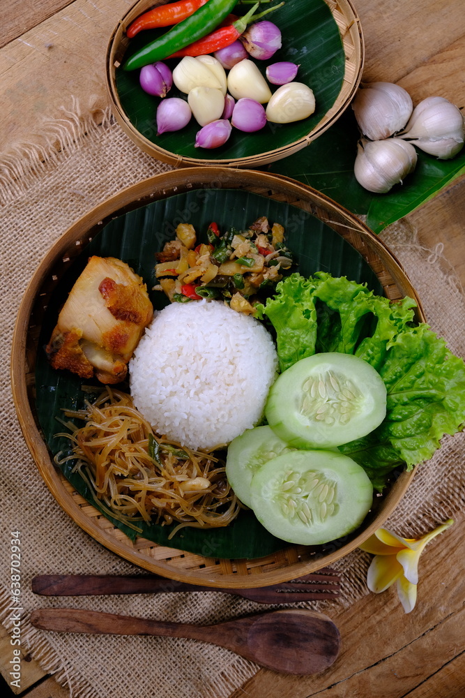Nasi Berkat Wonogiri. is rice with side dishes of fried chicken, stir-fried noodles with soy sauce, stir-fried spicy vegetables, fresh vegetables. nasi kenduri. ayam goreng, bakmi, lalapan. besek. Nasi Berkat Wonogiri. is rice with side dishes of fried chicken, stir-fried noodles with soy sauce, stir-fried spicy vegetables, fresh vegetables. nasi kenduri. ayam goreng, bakmi, lalapan. besek.
