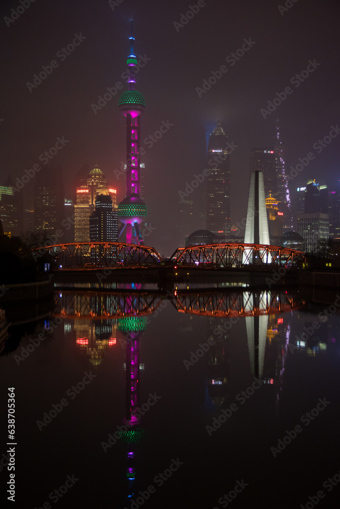 Fototapeta premium Glowing Shanghai: Oriental Pearl Tower Reflecting Cityscape at Night
