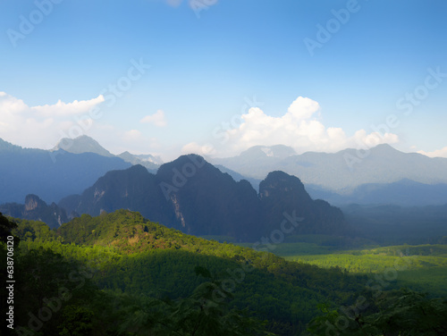 Scenic landscape with layers of mountain, green mountains in the fog, blue sky and white clouds in the background, wild tropical rainforest of Thailand © Darr.di