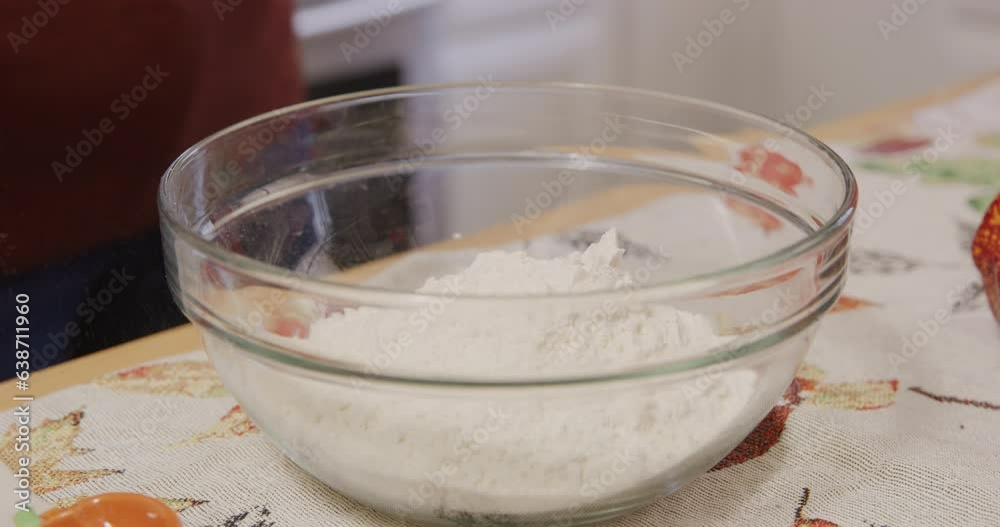 Pouring flour into mixing bowl closeup Pouring flour into mixing bowl closeup