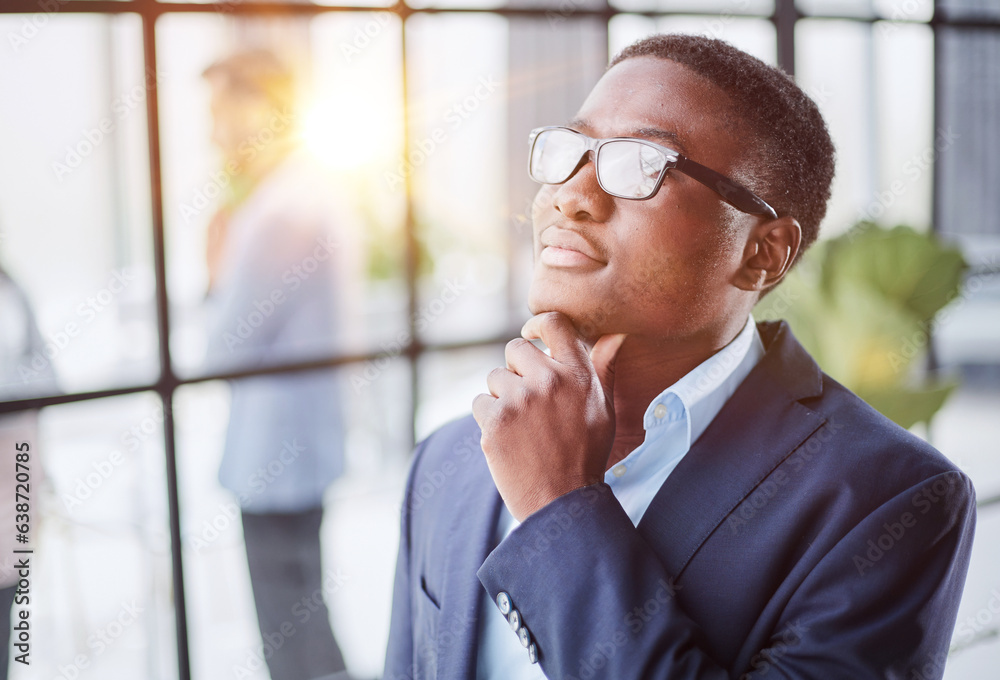 Head shot close up young thoughtful african american businessman entrepreneur looking away.