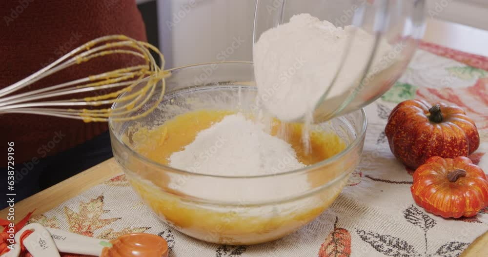 Adding flour into mix in mixing bowl and mixing with whisk