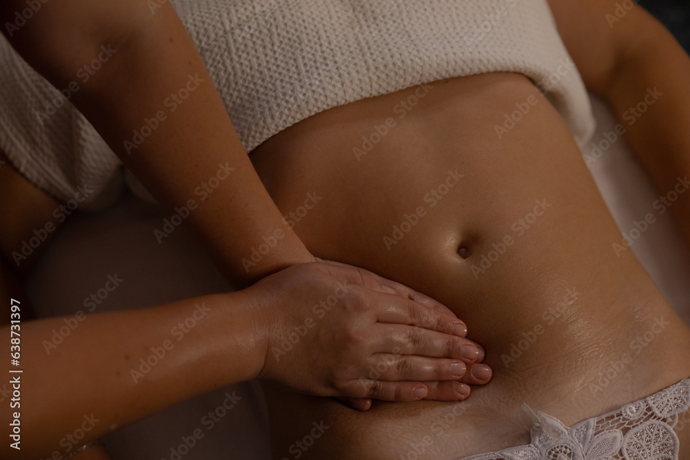 Relaxed girl getting belly massage in salon top view